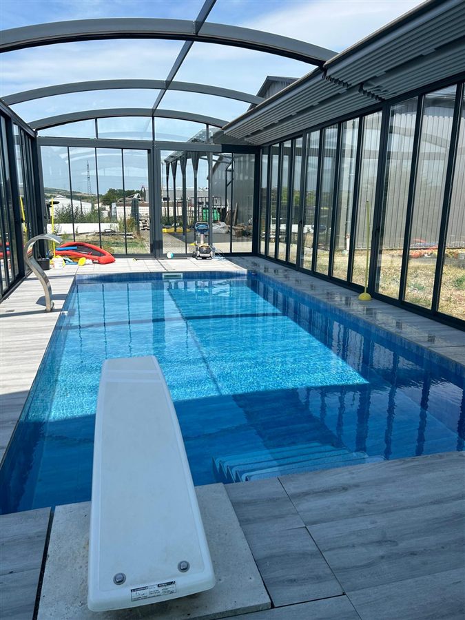Glasdach &uuml;ber einem Pool mit Sprungbrett